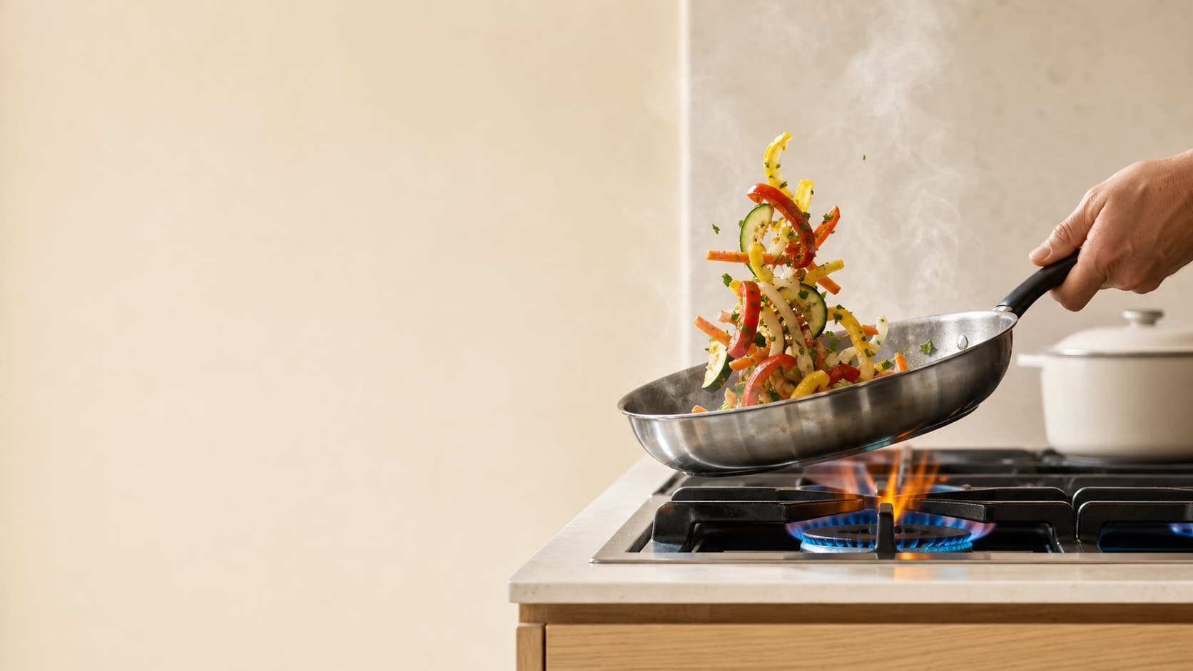Fresh vegetables tossed in a pan over a gas flame